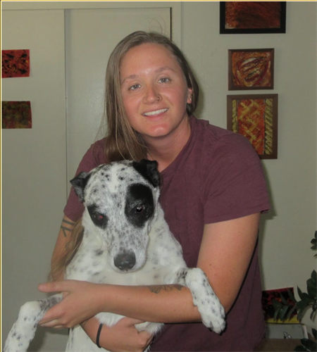 smiling white woman with blond hair holding her white and black dog