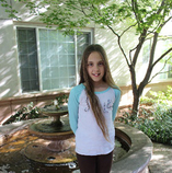 child posing next to tree